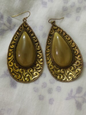 Beautiful golden with black tint oval earrings,With a stone in the centre